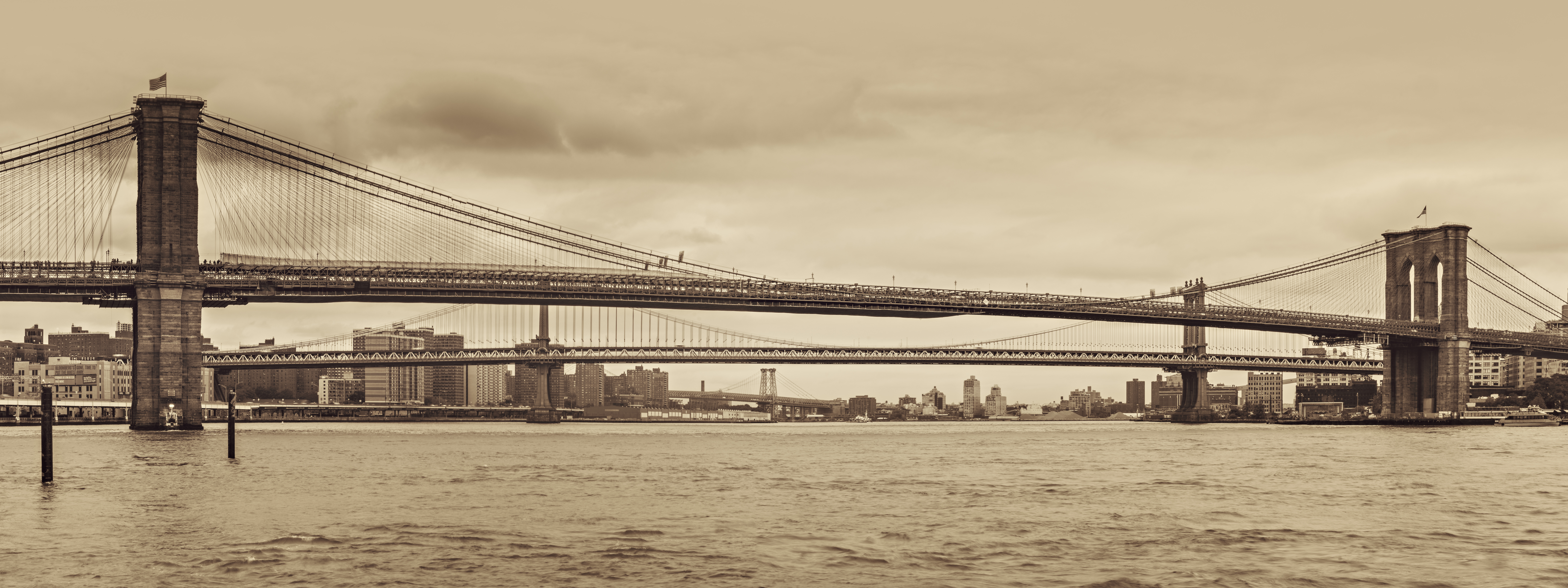 This is a photograph of The Brooklyn Bridge: NYC’s Iconic Landmark. This seems like a very historical and old picture of the Brooklyn Bridge.